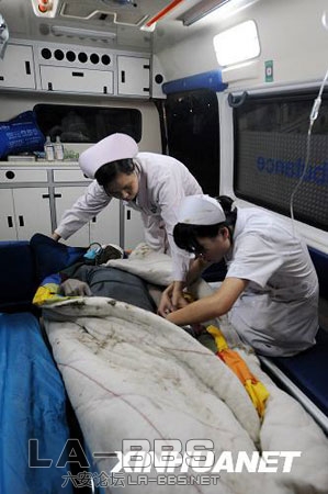 一名被困人员获救后被抬上救护车送往医院（8月13日摄）。