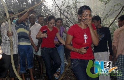 在印度南部卡纳塔克邦门格洛尔市的客机失事现场附近，当地居民表情悲痛